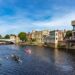 rowing boats on a blue river, lined with buildings against a blue sky, day trip to York